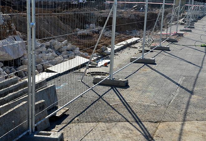 a row of temporary fence panels barricading a job site